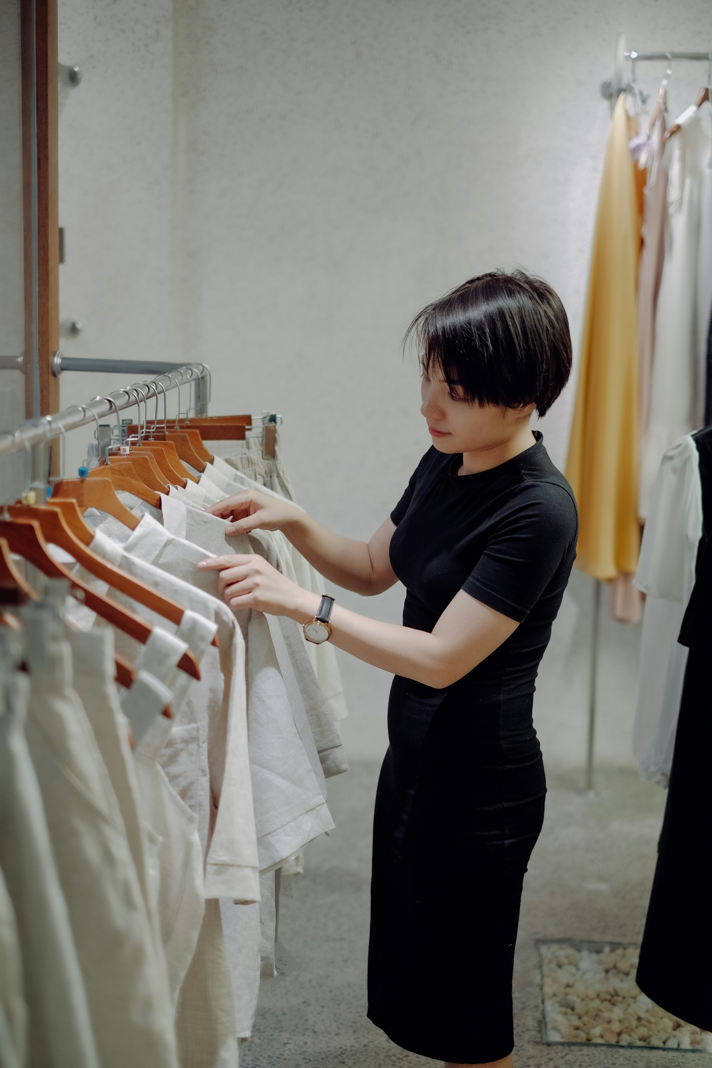 顾客在服装店内浏览衣架